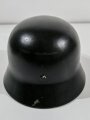 Stahlhelm Wehrmacht Modell 1935. In allen Teilen originales Stück. EF64, nach dem Krieg schwarz lackiert für Feuerwehrzwecke