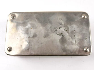 "Metallkasten als Hilfsirrigator" gehört so unter anderem in die Sanitätstasche für Sanitätsoffiziere. Maße 16,5 x 8 x 4cm