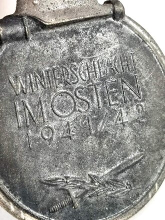 Medaille " Winterschlacht im Osten " mit Hersteller 55 im Bandring für " J.E. Hammer & Söhne, Geringswalde " mit Bandabschnitt