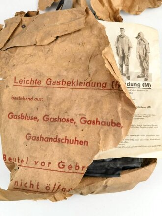 Satz "Leichte Gasbekleidung ( M ) " Ungebraucht, in der originalen aber defekten Umverpackung, dazu das ebenfalls originale Inhaltsverzeichnis mit Druckvermerk von 1942. Die Gummierung leicht verklebt, lässt sich problemlos lösen.