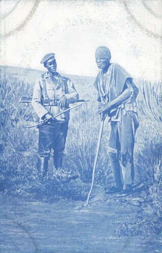 Postkarte, Deutsch Südwestafrika "Eingeborener Soldat (Bastard) mit gefangenem Herero", in den Ecken Abdrücke aus Album