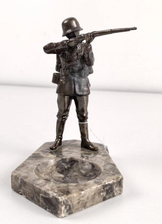 Spritzguss Figur mit Aschenbecher, einen stehenden Infanteristen mit Gewehr im Anschlag darstellend. Gesamthöhe mit Marmorsockel 17,5cm. Alte Reparaturstelle