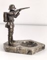 Spritzguss Figur mit Aschenbecher, einen stehenden Infanteristen mit Gewehr im Anschlag darstellend. Gesamthöhe mit Marmorsockel 17,5cm. Alte Reparaturstelle