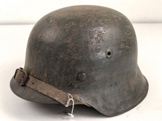 Heer, Stahlhelm Modell 1942. Originallack, Innenfutter vermutlich gewechselt, ungewöhnlicher Kinnriemen. Schwach abgeschlagener Hersteller und Lotnummer, nicht lesbar. Der Helm scheint mal mit Stahlwolle oder dergleichen gereinigt worden zu sein