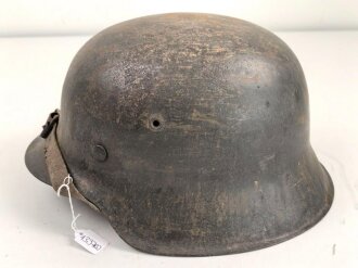 Heer, Stahlhelm Modell 1942. Originallack, Innenfutter vermutlich gewechselt, ungewöhnlicher Kinnriemen. Schwach abgeschlagener Hersteller und Lotnummer, nicht lesbar. Der Helm scheint mal mit Stahlwolle oder dergleichen gereinigt worden zu sein