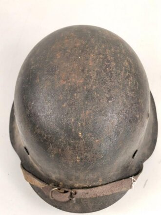 Heer, Stahlhelm Modell 1942. Originallack, Innenfutter vermutlich gewechselt, ungewöhnlicher Kinnriemen. Schwach abgeschlagener Hersteller und Lotnummer, nicht lesbar. Der Helm scheint mal mit Stahlwolle oder dergleichen gereinigt worden zu sein